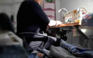 mujer sentada cosiendo a máquina