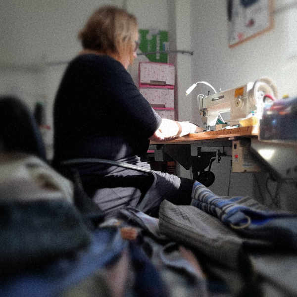 mujer sentada cosiendo a máquina